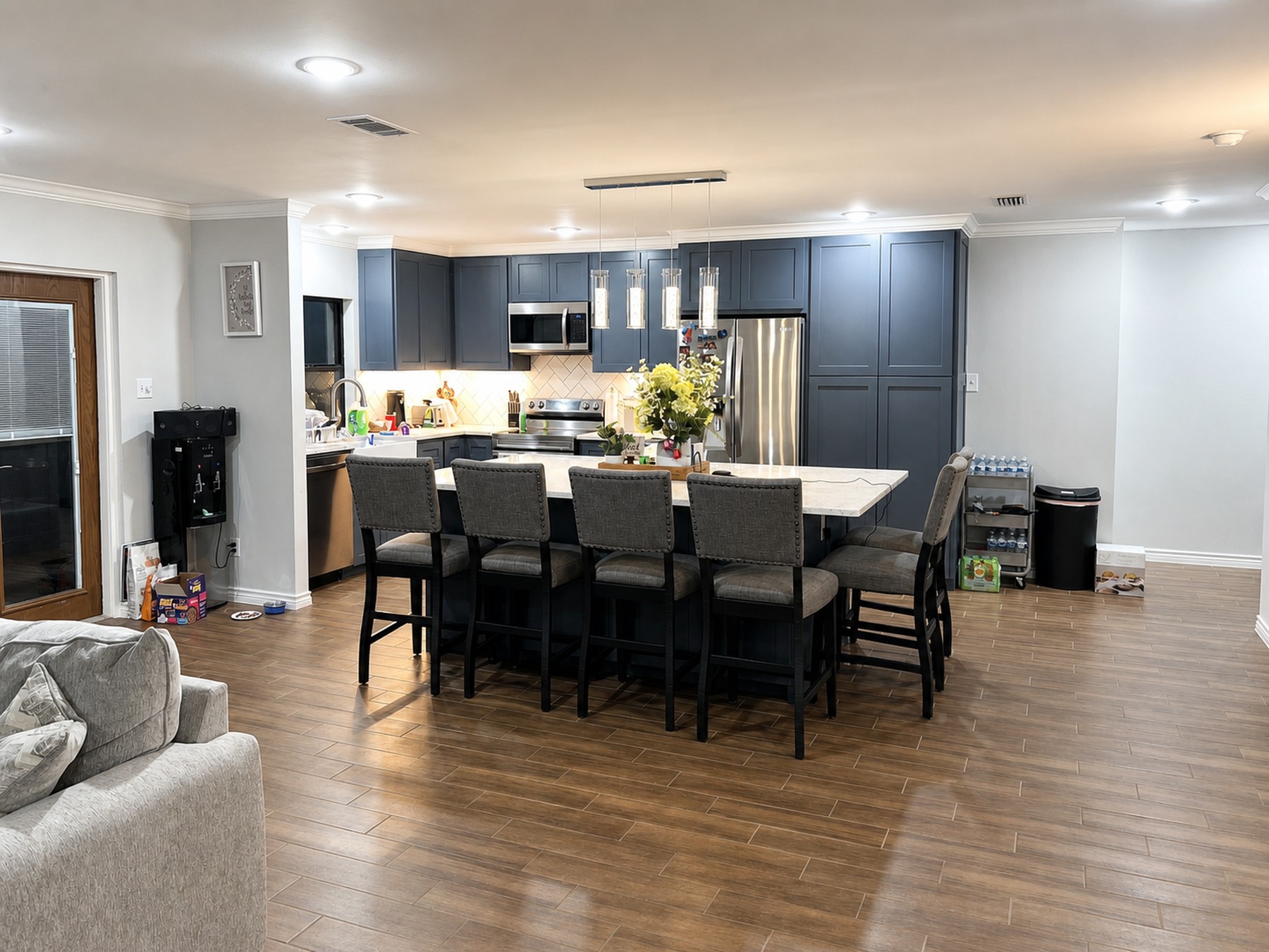 Finished kitchen and dining update with blue gray cabinetry and island seating