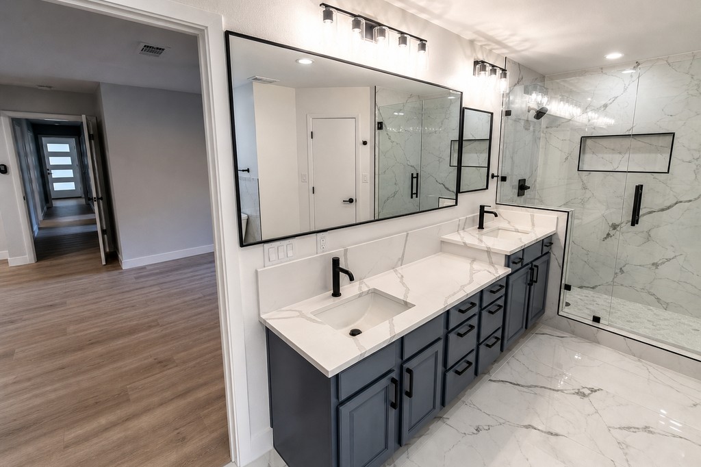 Full master bath view showing double vanity, shower, and freestanding tub